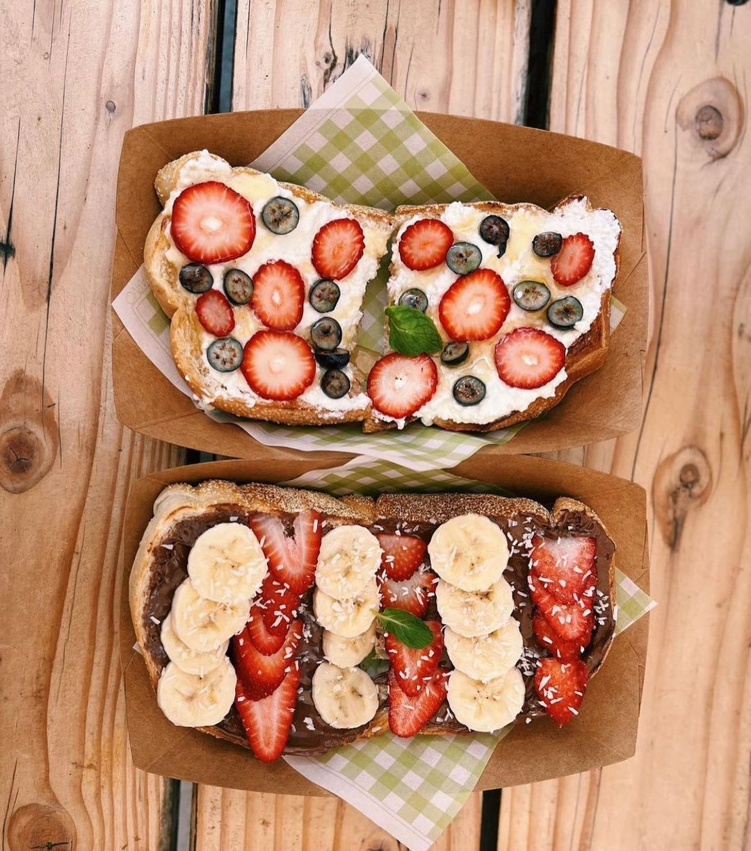 Two fruit-topped sandwiches with strawberries and bananas, perfect for spreading on toast.