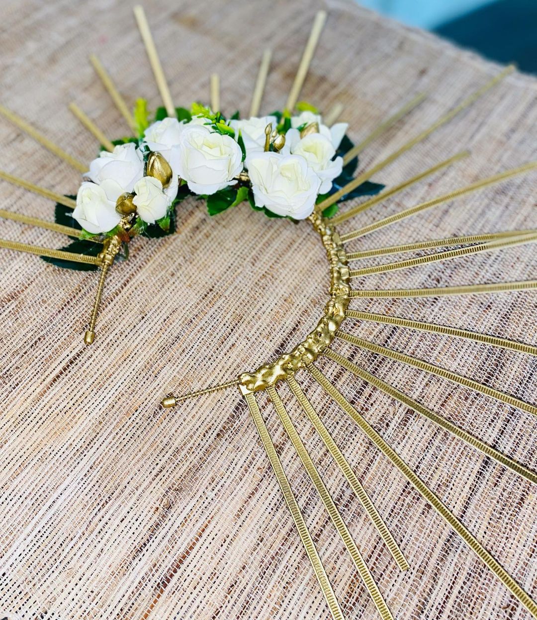 Elegant gold headpiece featuring white flowers and sticks, reminiscent of Disney Princess Floral Crowns, perfect for a royal look.