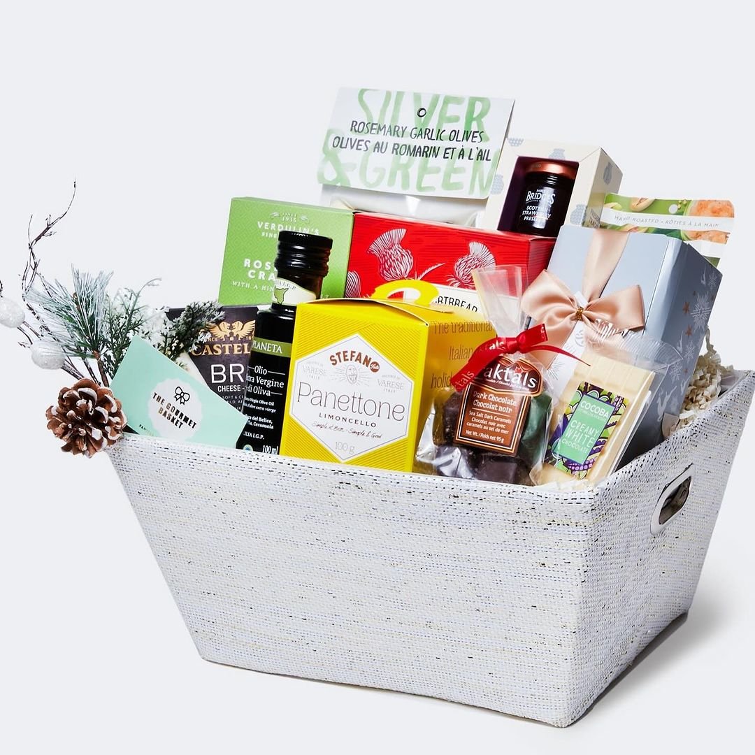 A white basket filled with gourmet food items of various types.