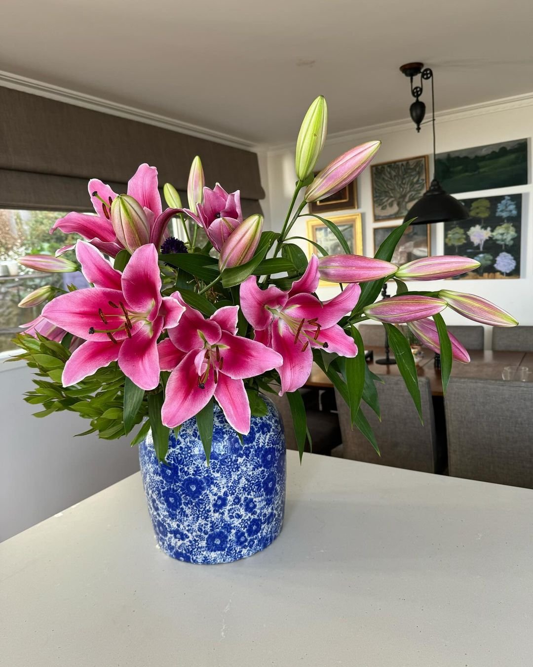 Blue and white vase with pink lilies, a beautiful floral arrangement.