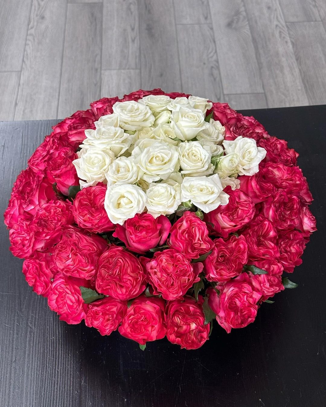 A vibrant arrangement of large red and white roses, showcasing their lush petals and elegant design.