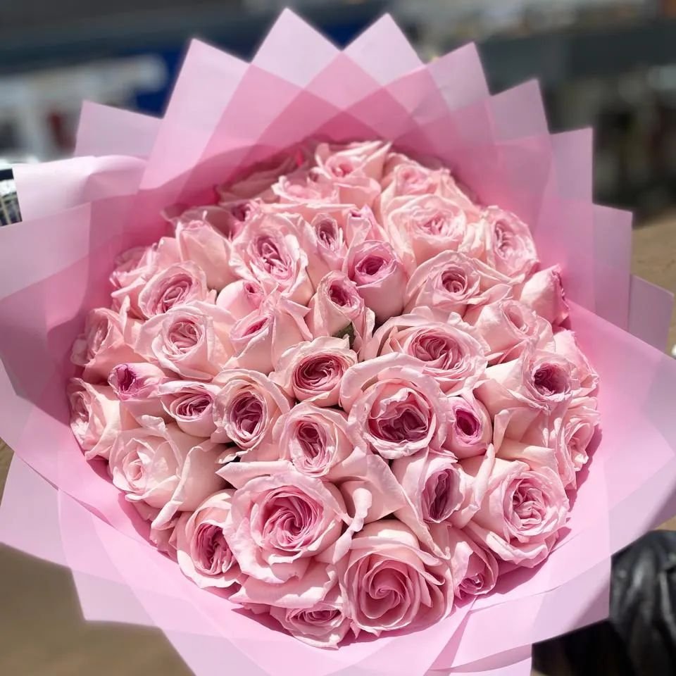 A vibrant bouquet of pink roses displayed elegantly in a store, showcasing fresh flower arrangements.